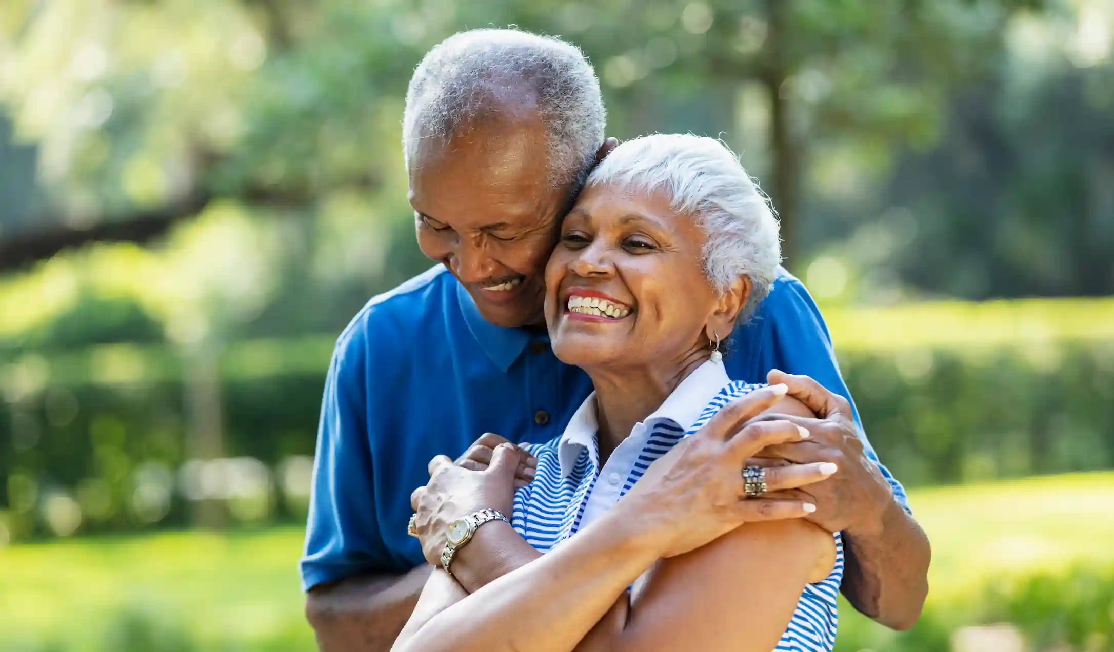A senior couple smiling near a park